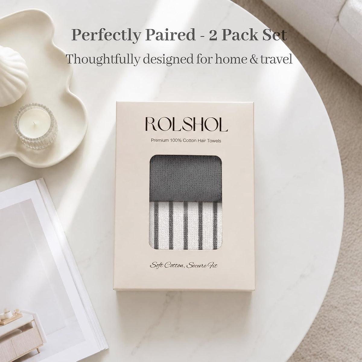 ROLSHOL Premium 100% Cotton Hair Towels in a cream gift box with window cutout, showing one dark gray solid towel and one gray-and-white striped towel. Box reads 'Soft Cotton, Secure Fit.' Styled on a marble table.