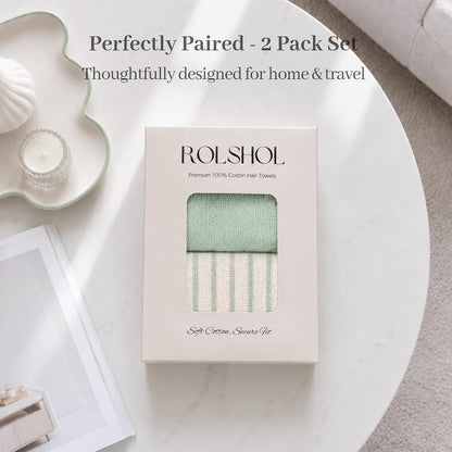 ROLSHOL Premium 100% Cotton Hair Towels in a cream gift box with window, showing a sage green solid towel and a green-striped cream towel. Text reads 'Soft Cotton, Secure Fit.' Styled on a marble table.