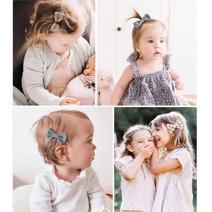 Four-panel lifestyle image showing young children wearing small fabric hair bow clips. Top left: toddler in gray cardigan with a brown bow. Top right: toddler in floral dress with gray bow ponytail. Bottom left: infant side profile with striped bow clip. Bottom right: two girls hugging, each wearing plaid bow clips.