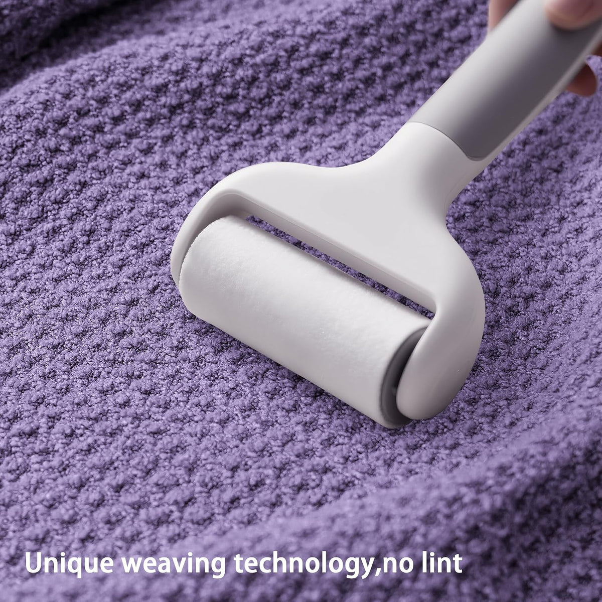 A white lint roller being pressed onto a textured purple waffle-weave fabric surface. Text at the bottom reads 'Unique weaving technology, no lint'.