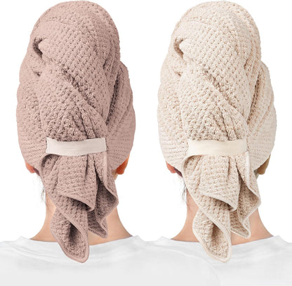 Two hair towel wraps shown from behind on a person, one in dusty mauve and one in light beige-clay. Both feature a waffle-knit texture, a fabric strap closure at the back, and a draped tail section at the nape.