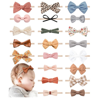 Collection of 21 baby bow headbands on elastic nylon bands in various fabrics and patterns including floral, leopard print, gingham, velvet, lace, and solid colors. Bottom left shows a sleeping infant wearing a rust-colored bow headband.