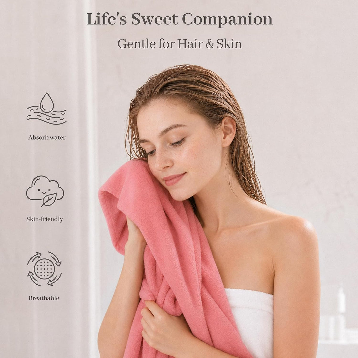 Woman with wet hair pressing a soft pink towel against her cheek and neck, eyes closed, wearing a white towel wrap. Left side shows three icons with labels: Absorb water, Skin-friendly, and Breathable. Text reads 'Life's Sweet Companion, Gentle for Hair & Skin.'