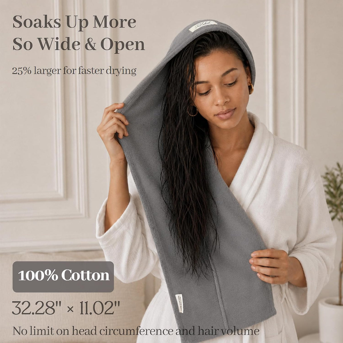 A woman in a white robe wraps a gray cotton hair towel around her long wet hair. Text reads 'Soaks Up More So Wide & Open,' '25% larger for faster drying,' '100% Cotton,' '32.28 x 11.02 inches,' and 'No limit on head circumference and hair volume.'