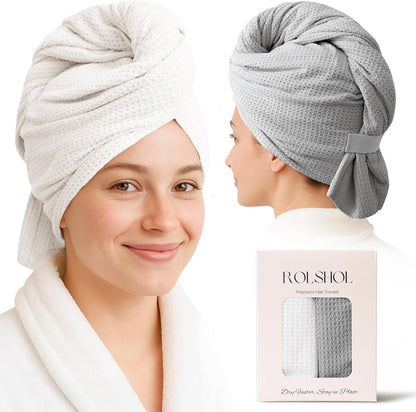Two women modeling waffle-texture hair towel wraps: one facing forward in white, one in profile in gray. A product box below reads 'ROLSHOL Premium Hair Towels' and 'Dry Faster, Stay in Place,' with both towels visible inside.