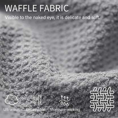 Close-up of gray waffle-textured fabric with white text reading 'WAFFLE FABRIC - Visible to the naked eye, it is delicate and soft.' Icons below label the material as ultra-soft, breathable, and moisture-wicking.