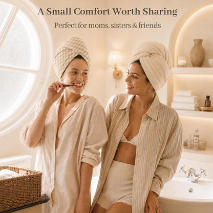 Two women in a bright bathroom, each wearing a cotton hair towel wrap turban on their heads. One brushes her teeth while the other smiles. Text reads: 'A Small Comfort Worth Sharing - Perfect for moms, sisters & friends.'